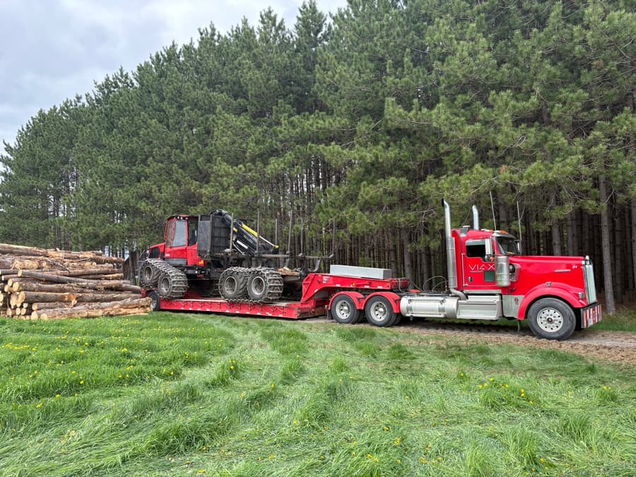 Porteur forestier sur fardier VIAX devant une plantation de pins